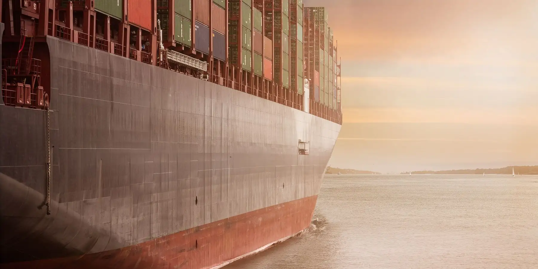 Container ship sailing at sunset