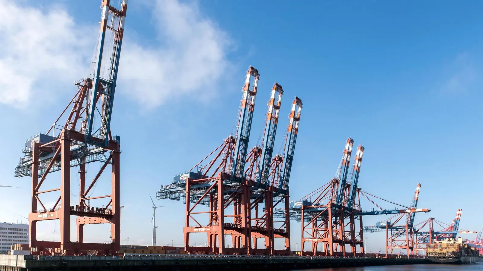 Container cranes of a port terminal under a blue sky